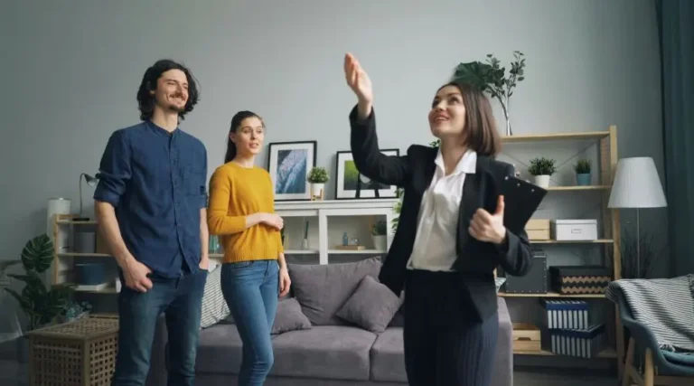 Agent d'immeuble à Montréal qui montre le salon d'une propriété à un couple