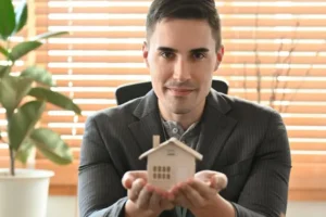Top courtier immobilier de Montréal qui présente une maison dans ses mains