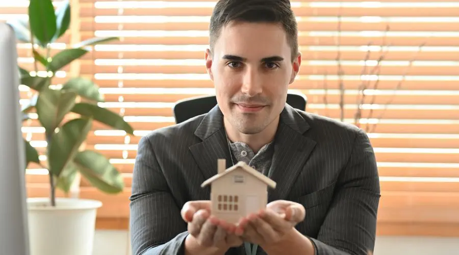 Top courtier immobilier de Montréal qui présente une maison dans ses mains